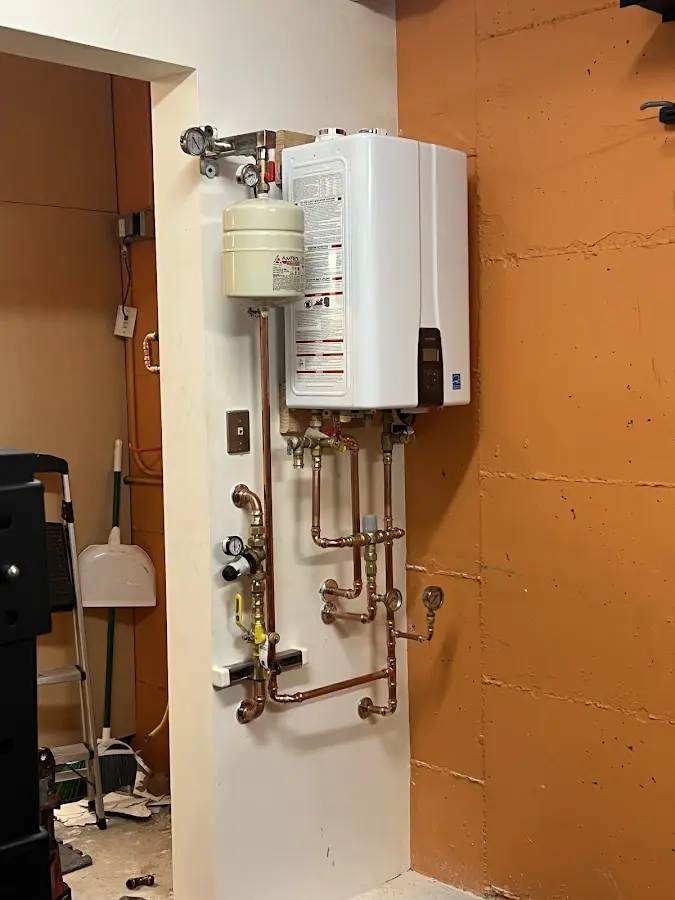 Plumbing technician inspecting water heater connections in Mission Hills